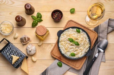 Frying pan with tasty risotto on wooden tableの写真素材
