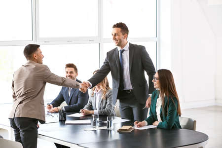 Human resources manager shaking hands with applicant after successful interview