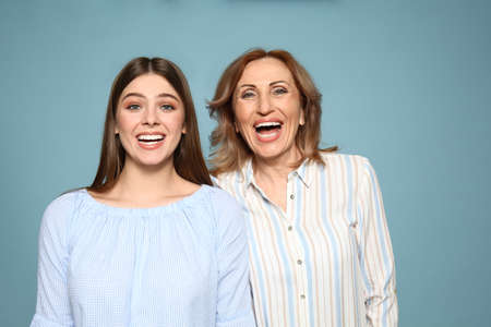 Portrait of happy mother with her daughter on color backgroundの写真素材
