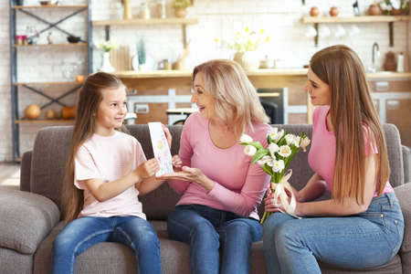 Little girl greeting her grandmother and mother at home