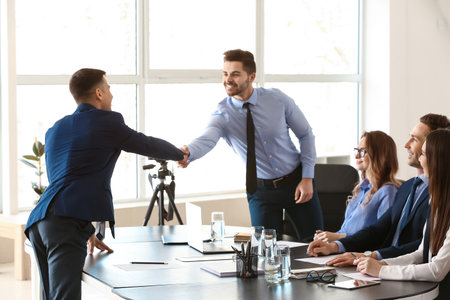 Human resources manager shaking hands with applicant after successful interview