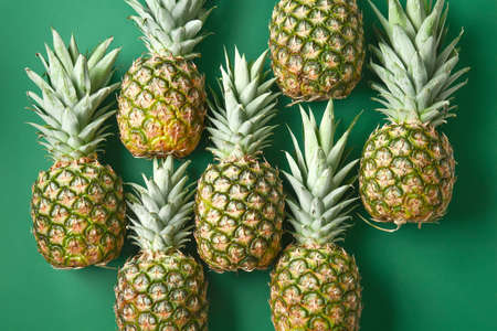 Many ripe pineapples on color backgroundの写真素材