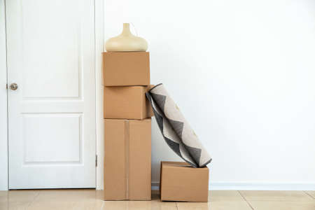 Cardboard boxes with belongings prepared for moving into new house near white wallの写真素材