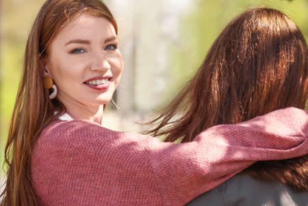 Beautiful young woman with her friend outdoorsの写真素材