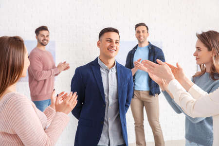 Visitors of art gallery applauding an artist at exhibition