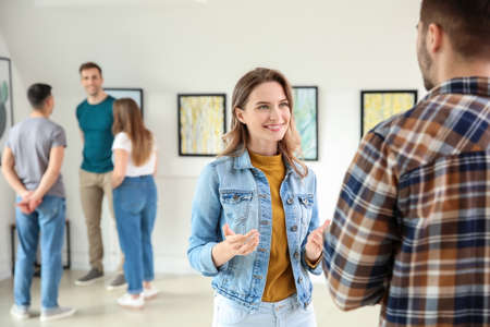 People at exhibition in modern art galleryの写真素材