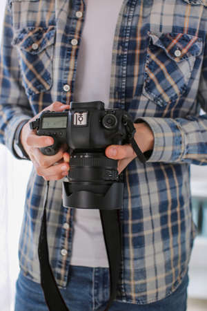 Teenage boy with photo camera at home, closeupの写真素材