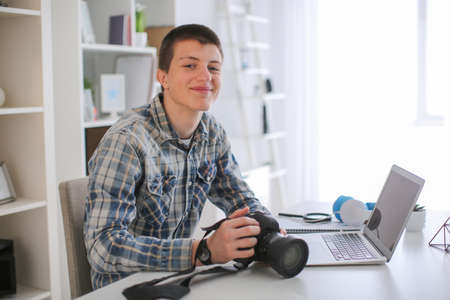 Teenage boy with photo camera at homeの写真素材