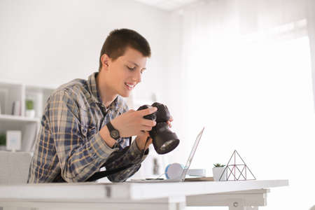 Teenage boy with photo camera at homeの写真素材