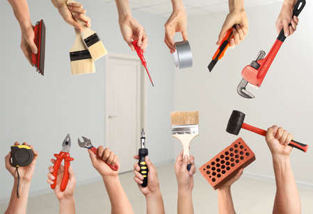Many hands with different construction tools indoorsの写真素材