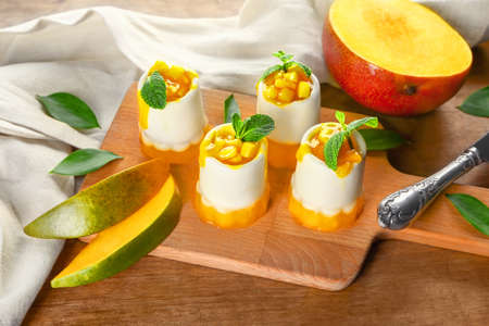 Board with tasty mango dessert on tableの写真素材