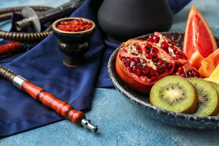 Plate with fruits and hookah on table