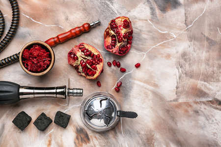 Composition with parts of hookah and pomegranate on marble background