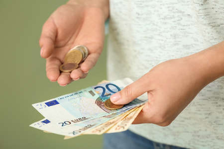 Young woman with money on color background, closeupの写真素材