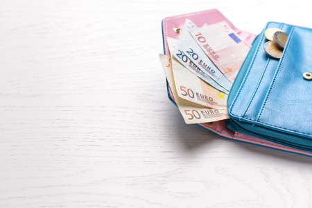 Wallet with money on white wooden tableの写真素材