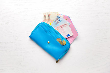 Wallet with money on white wooden tableの写真素材