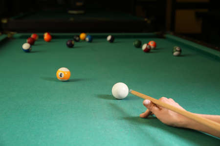 Young woman playing billiard in club