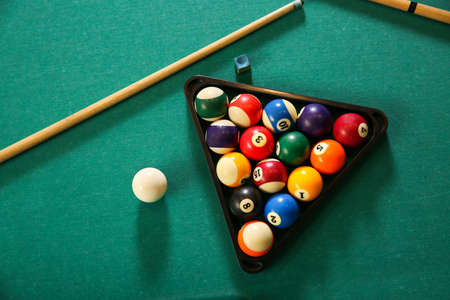 Billiard balls in triangle rack with cues on tableの写真素材