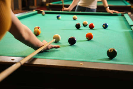 Young women playing billiard in club
