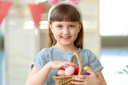 Little girl with basket full of painted Easter eggs at home