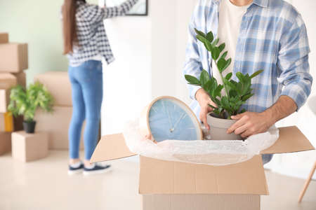 Young man unpacking belongings in his new house