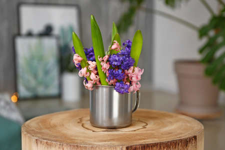 Cup with beautiful hyacinth flowers on table
