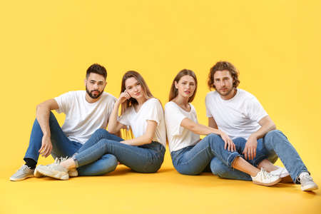 Stylish young people in jeans on color backgroundの写真素材