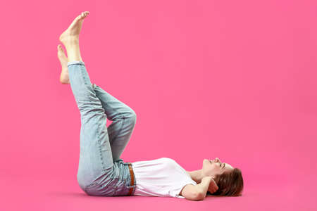 Stylish young woman in jeans on color backgroundの写真素材