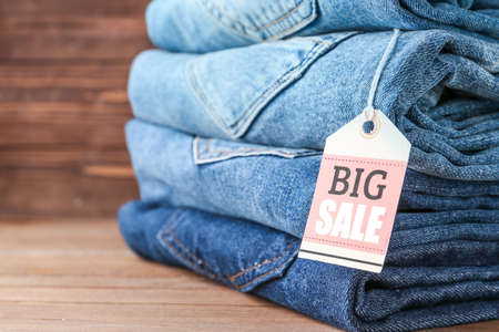 Stack of jeans clothes with tag on table, closeupの写真素材