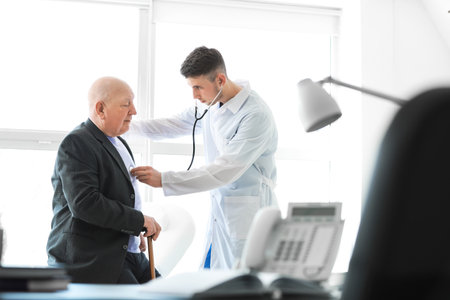 Doctor examining senior man in nursing homeの写真素材