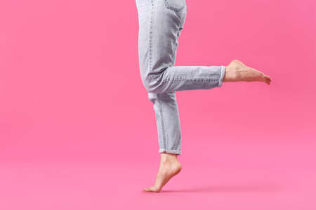 Stylish young woman in jeans on color backgroundの写真素材