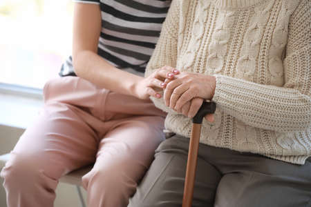 Caregiver with senior woman in nursing home, closeup