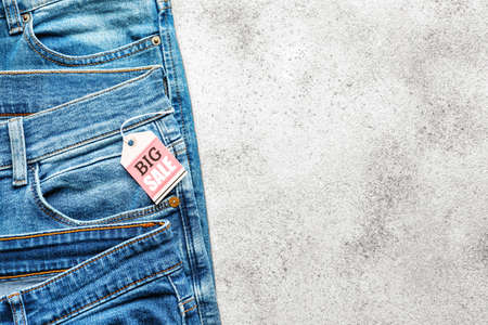 Stylish jeans with tag "Big Sale" on light backgroundの写真素材