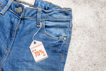 Stylish jeans with tag on light backgroundの写真素材