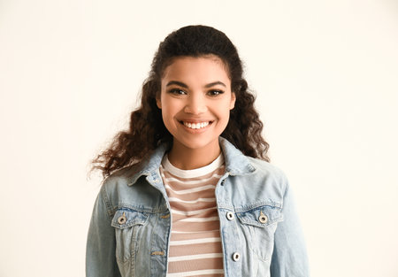 Portrait of cute African-American woman on light backgroundの写真素材