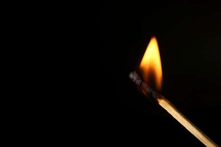 Burning match on black backgroundの写真素材