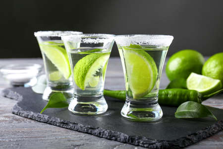 Glasses of tasty tequila on slate plate