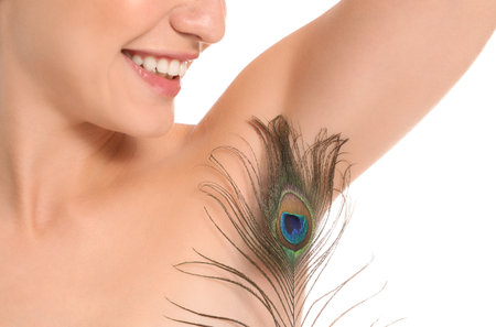 Beautiful young woman with feather on white background. Depilation conceptの写真素材