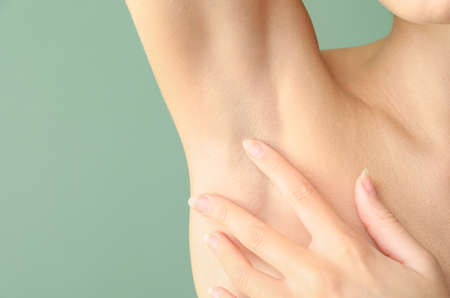 Beautiful young woman after laser hair removal procedure on color background