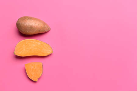Fresh sweet potatoes on color backgroundの写真素材
