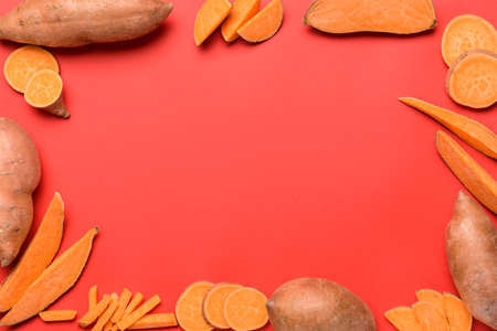 Frame made of fresh sweet potatoes on color background