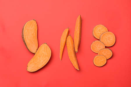 Fresh sweet potatoes on color background