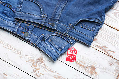 Jeans pants with shopping tag on white wooden backgroundの写真素材