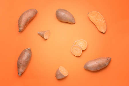 Fresh sweet potatoes on color backgroundの写真素材