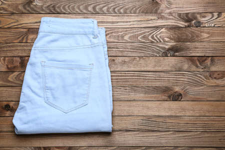 Stylish jeans pants on wooden backgroundの写真素材