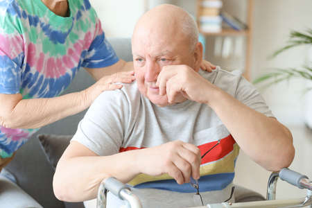 Senior woman calming her sad friend in nursing home