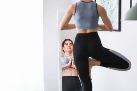 Young woman practicing yoga at homeの写真素材