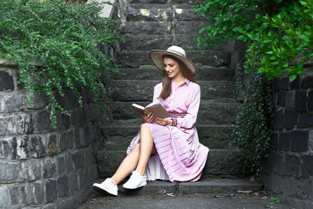 Beautiful young woman reading book in parkの写真素材