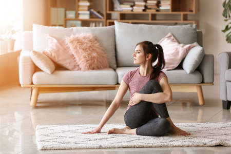 Young woman practicing yoga at home