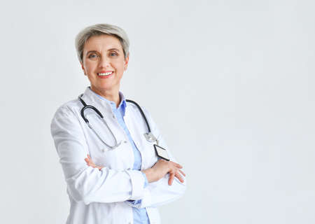 Mature female doctor on light backgroundの写真素材